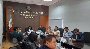 diferentes personas sentadas en un salón alrededor de una mesa